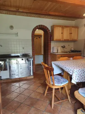 a kitchen with a table and a table and chairs at Apartma Hodnik Bohinj Uskovnica in Srednja Vas v Bohinju