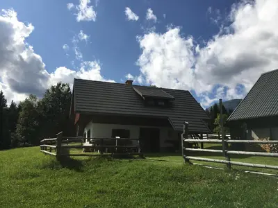 a house with a fence in front of it at Apartma Hodnik Bohinj Uskovnica in Srednja Vas v Bohinju