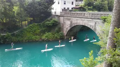 a group of people on surfboards in the water under a bridge at Apartma Gorjan in Tolmin
