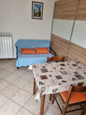 a room with a table and a bed and a table and chairs at Apartma Gorjan in Tolmin