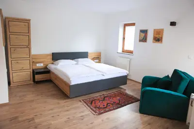 a bedroom with a bed and a blue couch at Apartments Katrca Bežigrad in Ljubljana