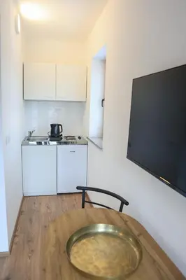 a kitchen with a wooden table with a plate on the floor at Apartments Katrca Bežigrad in Ljubljana
