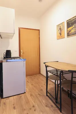 a room with a table and a wooden door at Apartments Katrca Bežigrad in Ljubljana