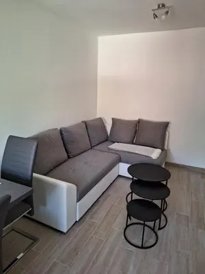 a living room with a couch and two stools at ALPSKA ROŽA in Kranjska Gora
