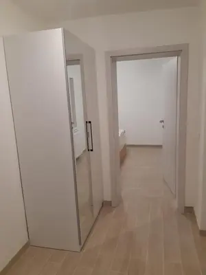 an empty hallway with two doors and a mirror at ALPSKA ROŽA in Kranjska Gora