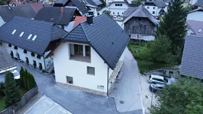 an overhead view of a white house with a black roof at ALPSKA ROŽA in Kranjska Gora