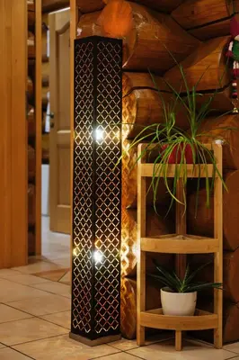 a floor lamp in a lobby with a plant at Mia Bella luxury chalet in Slovenske Konjice in Slovenske Konjice