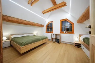 a bedroom with a bed and two windows at Mia Bella luxury chalet in Slovenske Konjice in Slovenske Konjice