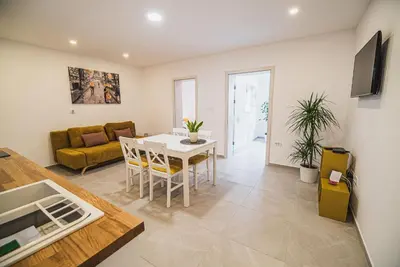 a living room with a table and a couch at Gotar Apartment with Garden in Kobarid
