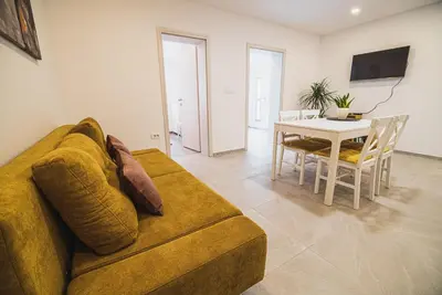 a living room with a couch and a table at Gotar Apartment with Garden in Kobarid