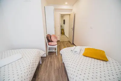 a small room with two beds and a chair at Gotar Apartment with Garden in Kobarid