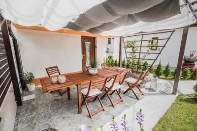 a patio with a wooden table and chairs at Gotar Apartment with Garden in Kobarid