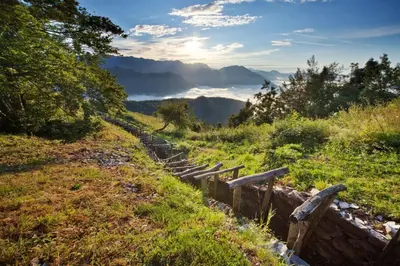 a fence on a hill with a view of a mountain at Gotar Apartment with Garden in Kobarid