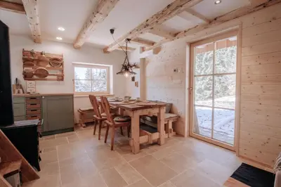 a dining room with a wooden table and chairs at Lovely Cottage in a mountain wilderness of the National Park in Srednja Vas v Bohinju