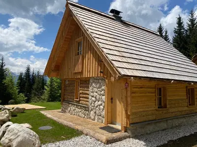 a log cabin with a roof on top of it at Lovely Cottage in a mountain wilderness of the National Park in Srednja Vas v Bohinju