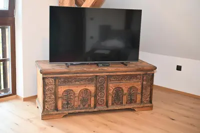 a television sitting on top of a wooden cabinet at SLO-ETNO HOUSE GOSTECE-Vintage Apartma in Mozirje