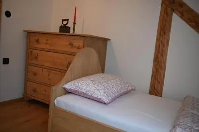 a bedroom with a bed and a dresser at SLO-ETNO HOUSE GOSTECE-Vintage Apartma in Mozirje