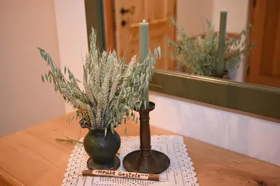 two vases sitting on a table with a candle at SLO-ETNO HOUSE GOSTECE-Vintage Apartma in Mozirje