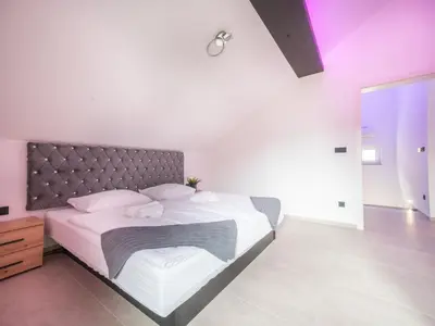 a bedroom with a large bed with white sheets and pillows at Resort TimAJA - pool, massage pool, sauna in Trebnje