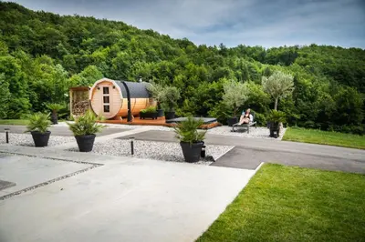 a person sitting on a bench in front of a tiny house at Resort TimAJA - pool, massage pool, sauna in Trebnje