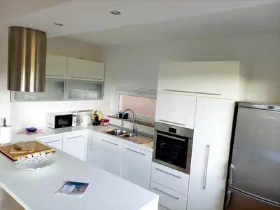 a kitchen with white cabinets and a stainless steel refrigerator at Jenny Apartment with Jacuzzi in Brezovica