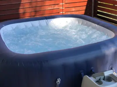 a bath tub with water in it next to a sink at Jenny Apartment with Jacuzzi in Brezovica