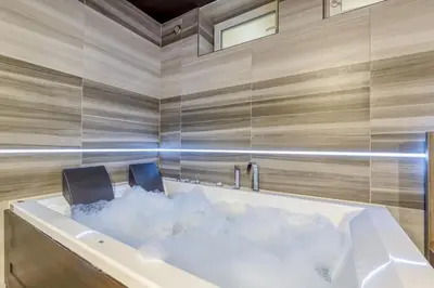 a bath tub with a cloud in the middle at Private Wellness Apartment in Trebnje