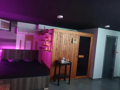 a bedroom with purple walls and a bed with a table at Private Wellness Apartment in Trebnje