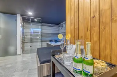 two bottles of wine on a table with wine glasses at Private Wellness Apartment in Trebnje