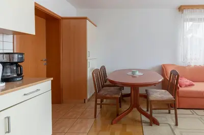 a kitchen with a table and chairs and a couch at Apartma Ana in Preserje
