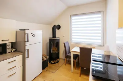 a kitchen with a refrigerator and a table with a stove at Mojstranka in Mojstrana