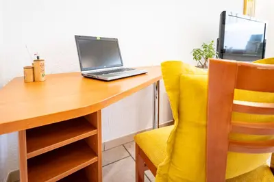 a laptop computer sitting on a wooden desk with a chair at Apartment Ajdi in Ajdovščina