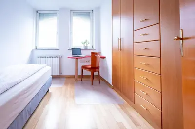 a bedroom with a bed and a desk with a laptop at Apartment Ajdi in Ajdovščina