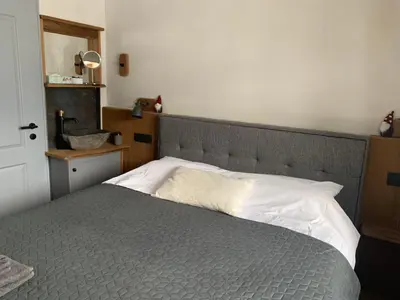 a bedroom with a large bed with a gray headboard at Hiša Pod gorami II****-house with wellness in Kranjska Gora