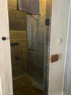 a bathroom with a shower with a glass door at Hiša Pod gorami II****-house with wellness in Kranjska Gora