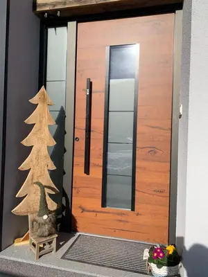 a christmas tree sitting in front of a door at Hiša Pod gorami II****-house with wellness in Kranjska Gora