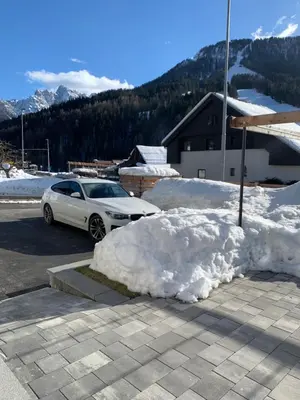 a pile of snow next to a car in a parking lot at Hiša Pod gorami II****-house with wellness in Kranjska Gora