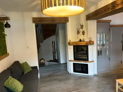 a living room with a couch and a fireplace at Hiša Pod gorami II****-house with wellness in Kranjska Gora