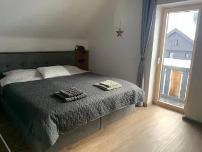 a bedroom with a bed with two towels on it at Hiša Pod gorami II****-house with wellness in Kranjska Gora