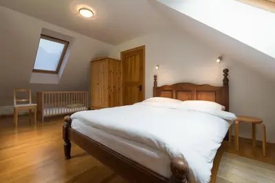 a bedroom with a large bed with white sheets at House Jelenko in Bovec