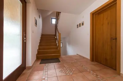 a hallway with a stairway with a wooden door and a staircase at House Jelenko in Bovec