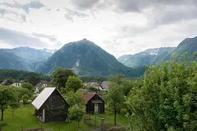 a small village with mountains in the background at House Jelenko in Bovec