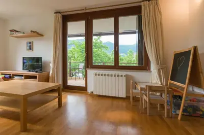 a living room with a table and a large window at House Jelenko in Bovec