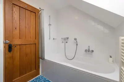 a bathroom with a shower and a tub with a door at House Jelenko in Bovec