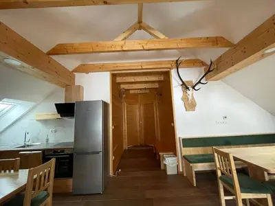 a kitchen and dining room with a table and a refrigerator at Apartma LD Puščava in Lovrenc na Pohorju