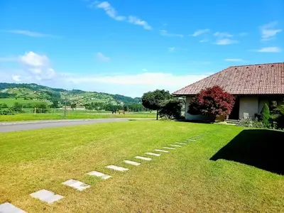 a grassy yard next to a house and a road at Apartma Stanka in Bistrica ob Sotli