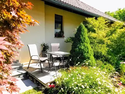 a patio with two chairs and a table in front of a house at Apartma Stanka in Bistrica ob Sotli