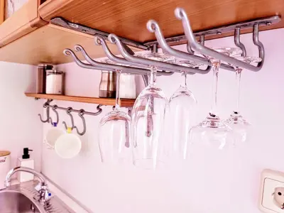 a bunch of wine glasses hanging from a rack in a kitchen at Apartma Stanka in Bistrica ob Sotli