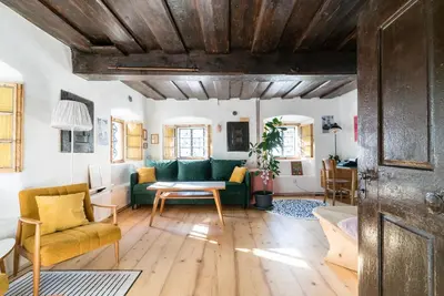 a living room with a green couch and a table at Hiša Borov Gaj in Mojstrana