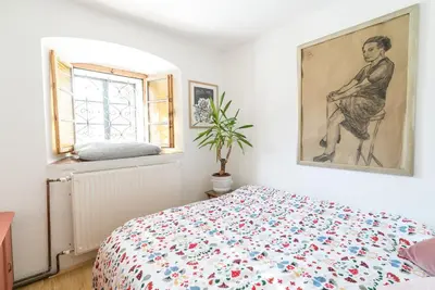 a bedroom with a bed and a painting on the wall at Hiša Borov Gaj in Mojstrana